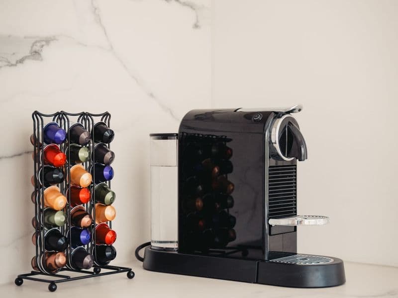 Modern capsule coffee machine with a veriety of colorful coffee pods on a sleek kitchen countertop