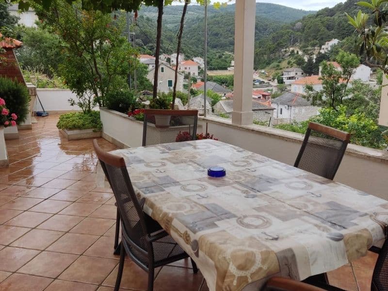 Spacious outdoor dining terrace with a large table and sea view in Povlja Brač