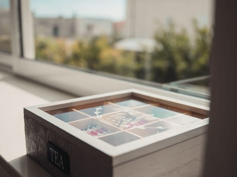 Assorted tea box for guests located in a bright, modern kitchen area