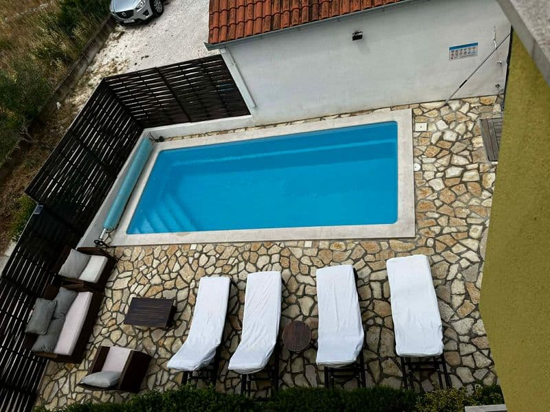 Shared outdoor swimming pool with sun loungers