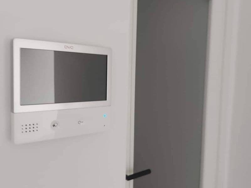 Secure video door phone and intercom display on a white wall in the entryway