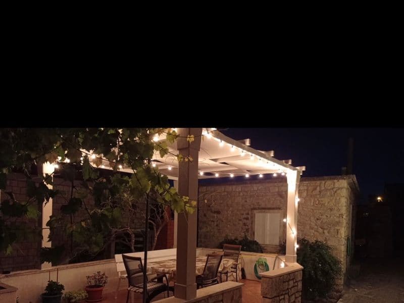 Evening terrace with ambient lighting and dining area in Povlja Brač Dalmakeys